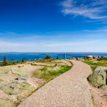 Gravel path across pink granite on Cadillac Mountain summit overlooking island-dotted Frenchman Bay, Maine