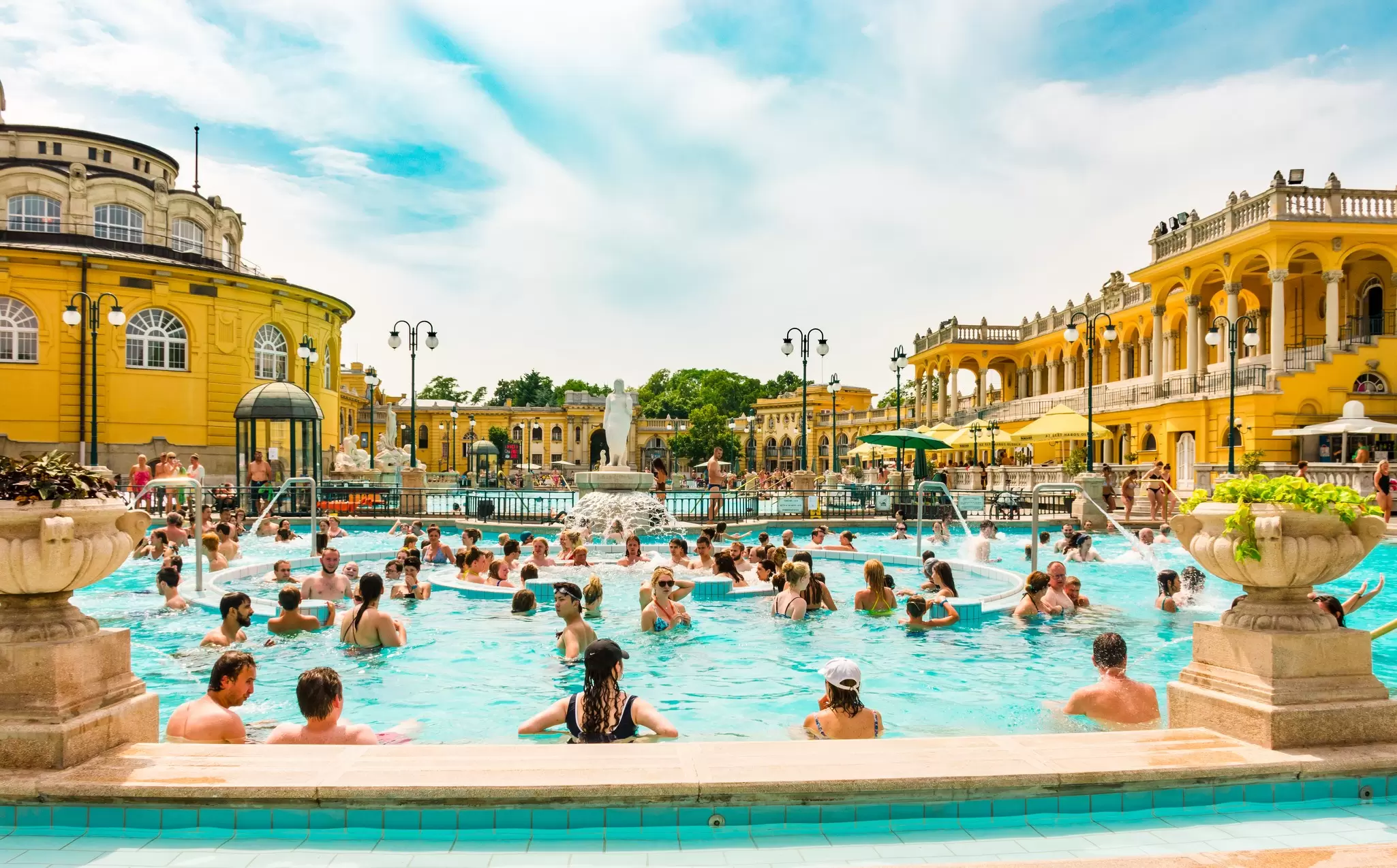 People relaxing in the outdoor pool at Széchenyi Baths in Budapest, Hungary.