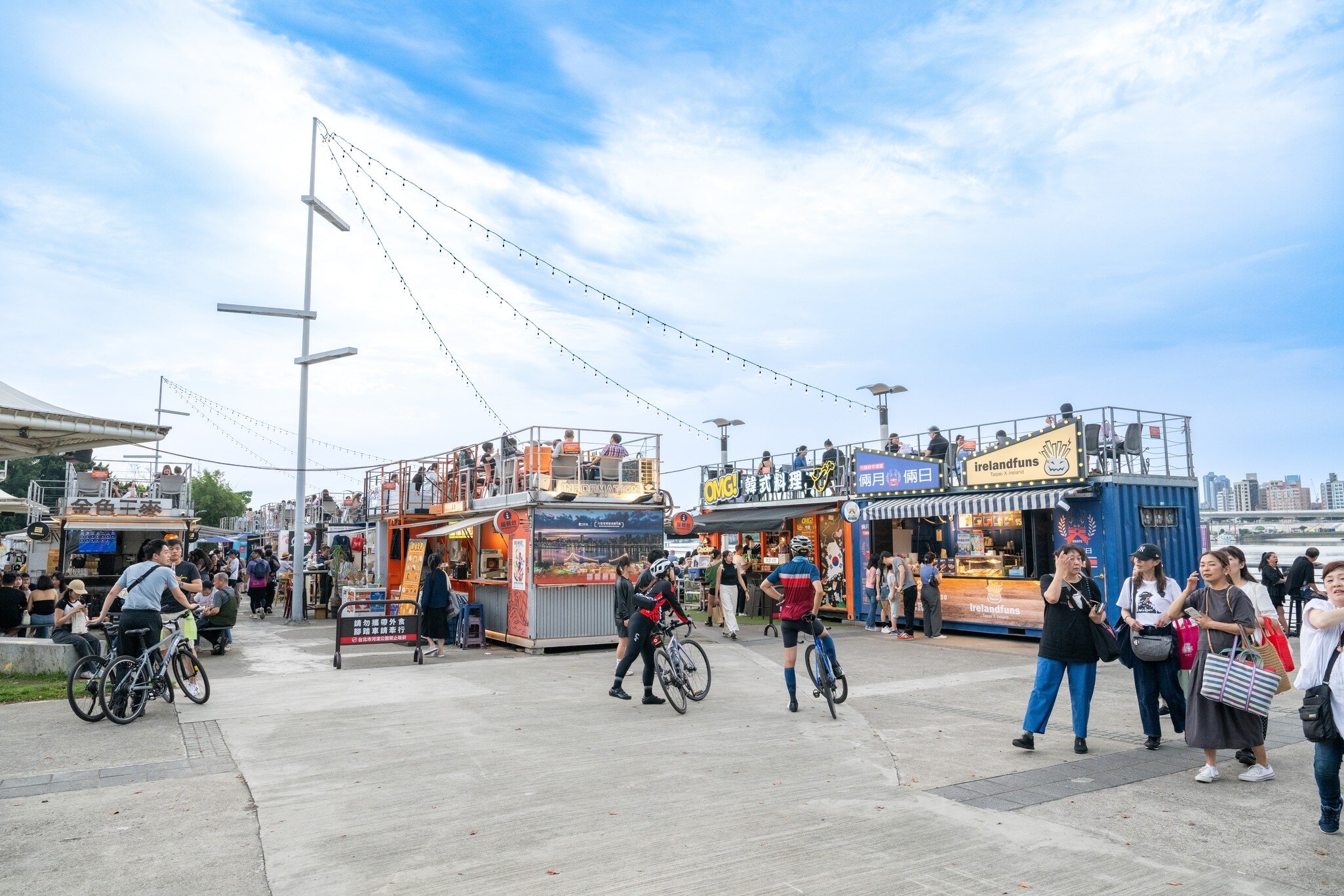 People enjoying Pier 5 food stalls at Dadaocheng Wharf in Taipei, Taiwan on a sunny day.