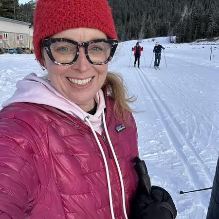 Destination Editor Melissa Yeager smiles at the camera from a ski trail