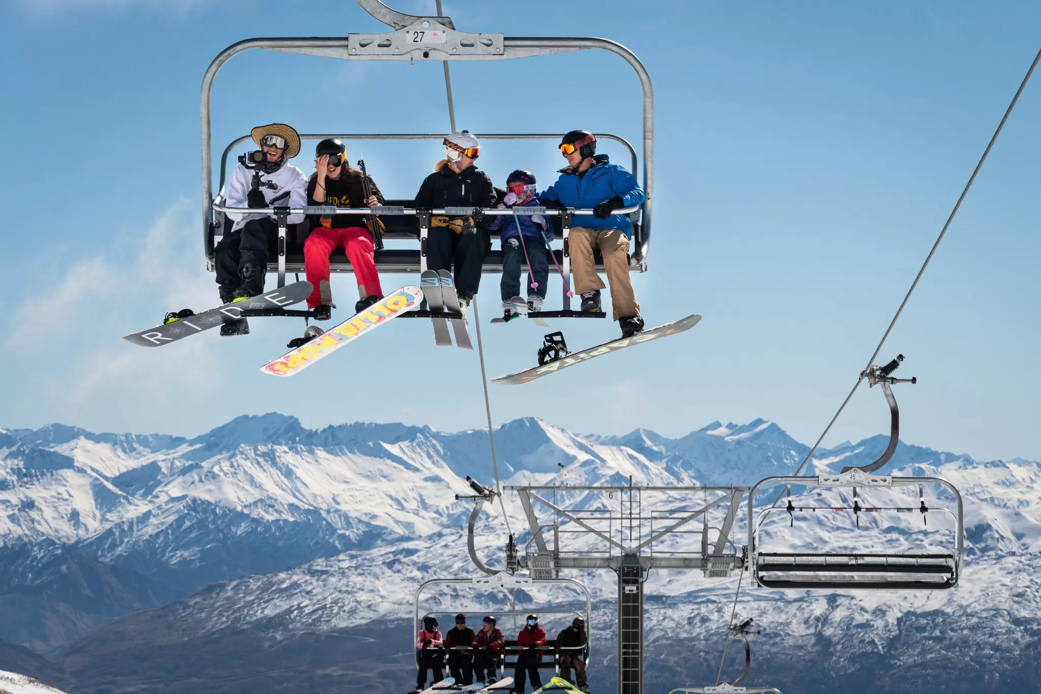 Skiers ride a chairlift over snowy slopes near Queenstown, New Zealand. 