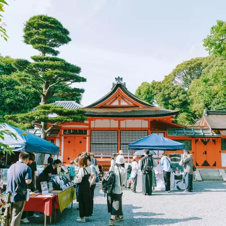 A pop-up tea shop stands at the entrance to a red-painted shrine in Kyoto. 
