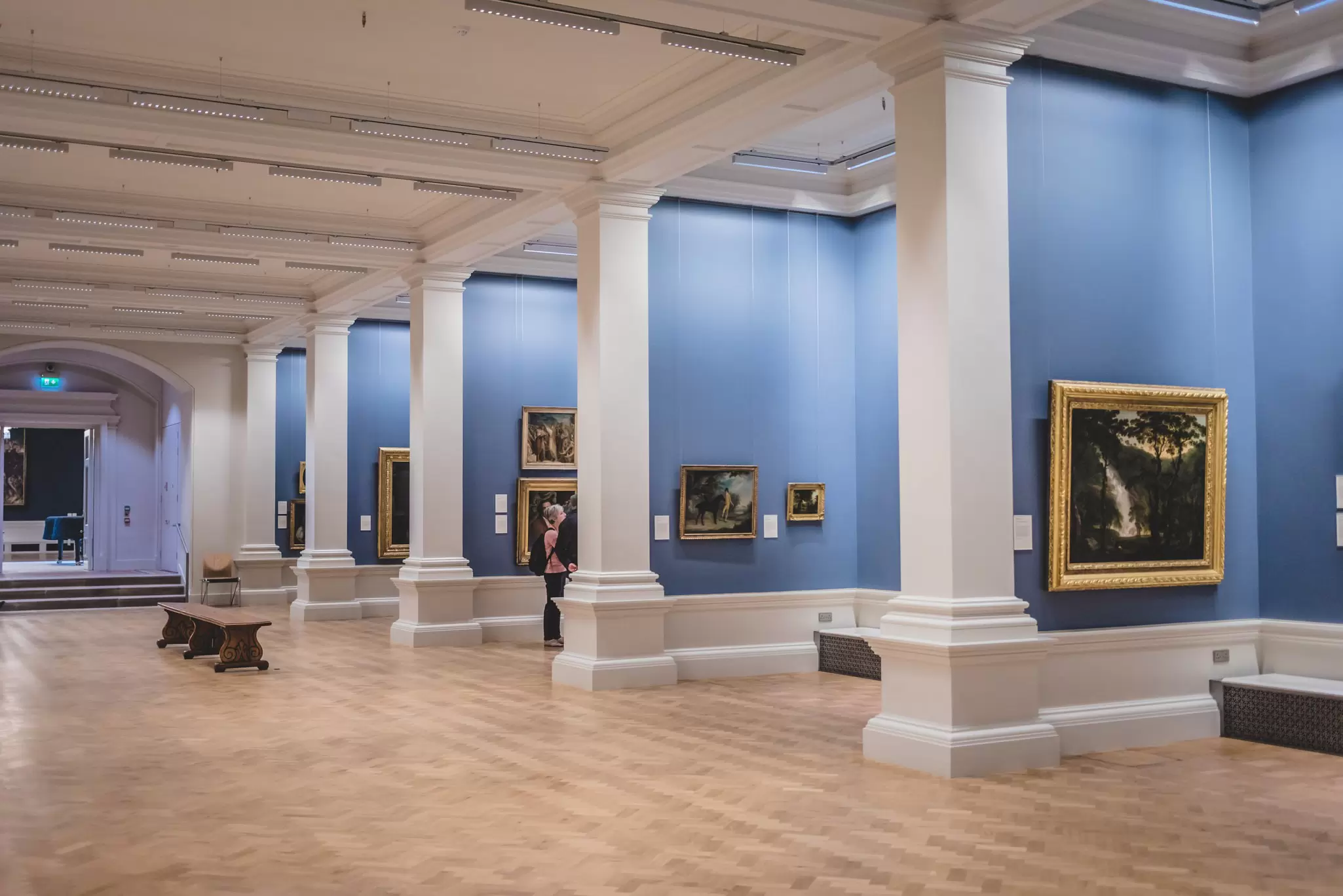 Paintings displayed on blue walls in the National Gallery of Ireland