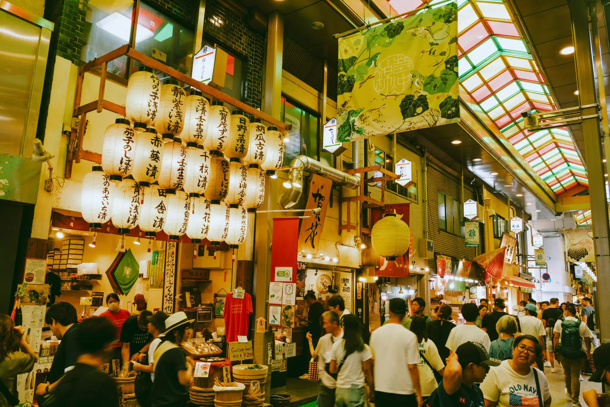 Shoppers, diners and browsers wander the covered halls of a busy food market.