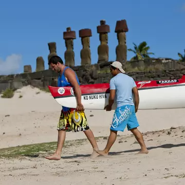 Men carrying kayak on Anakena Beach on Rapa Nui (Easter Island), Chile