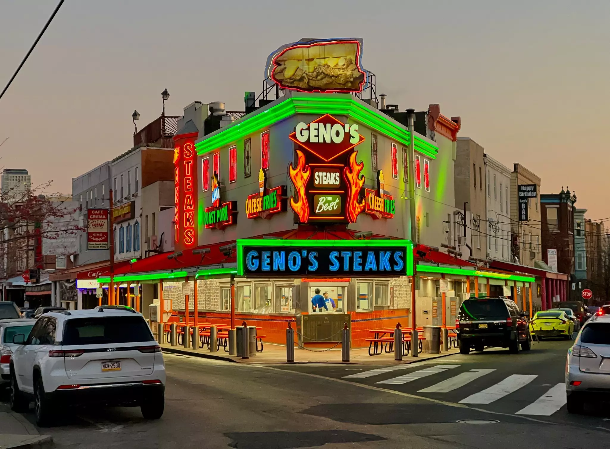 Geno's Steaks, a mainstay of Philadelphia's Italian Market, glows in neon at sunrise.