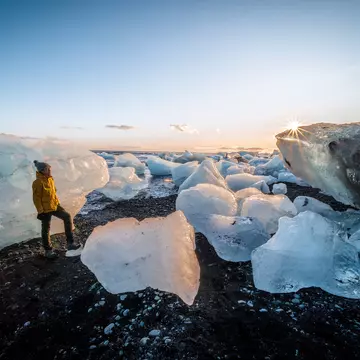 At the Diamond Beach, the icebergs which fill the Jökulsárlón glacier lagoon wash up on shore, creating a stark contrast with the volcanic black sand. This beautiful display makes it a favourite location for photographers and nature-lovers.