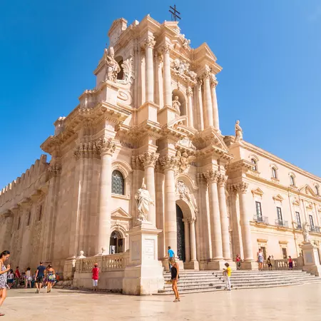 Tourists and locals visit main square Piazza del Duomo in Ortigia, Syracuse. 