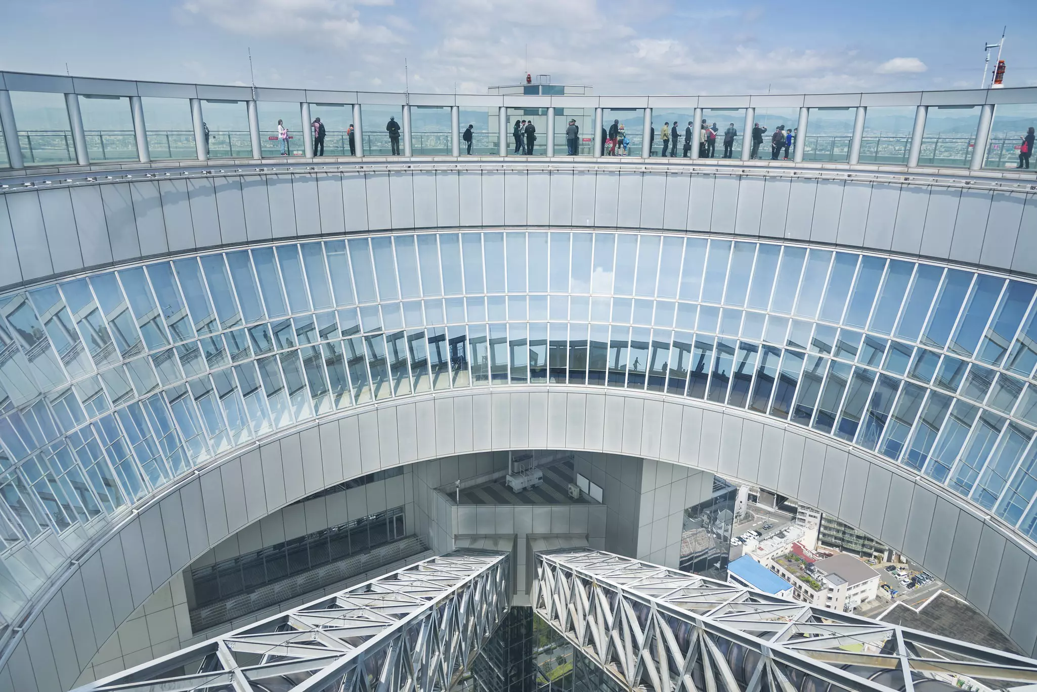 The vast round open-air observation deck of a glass and steel skyscraper.