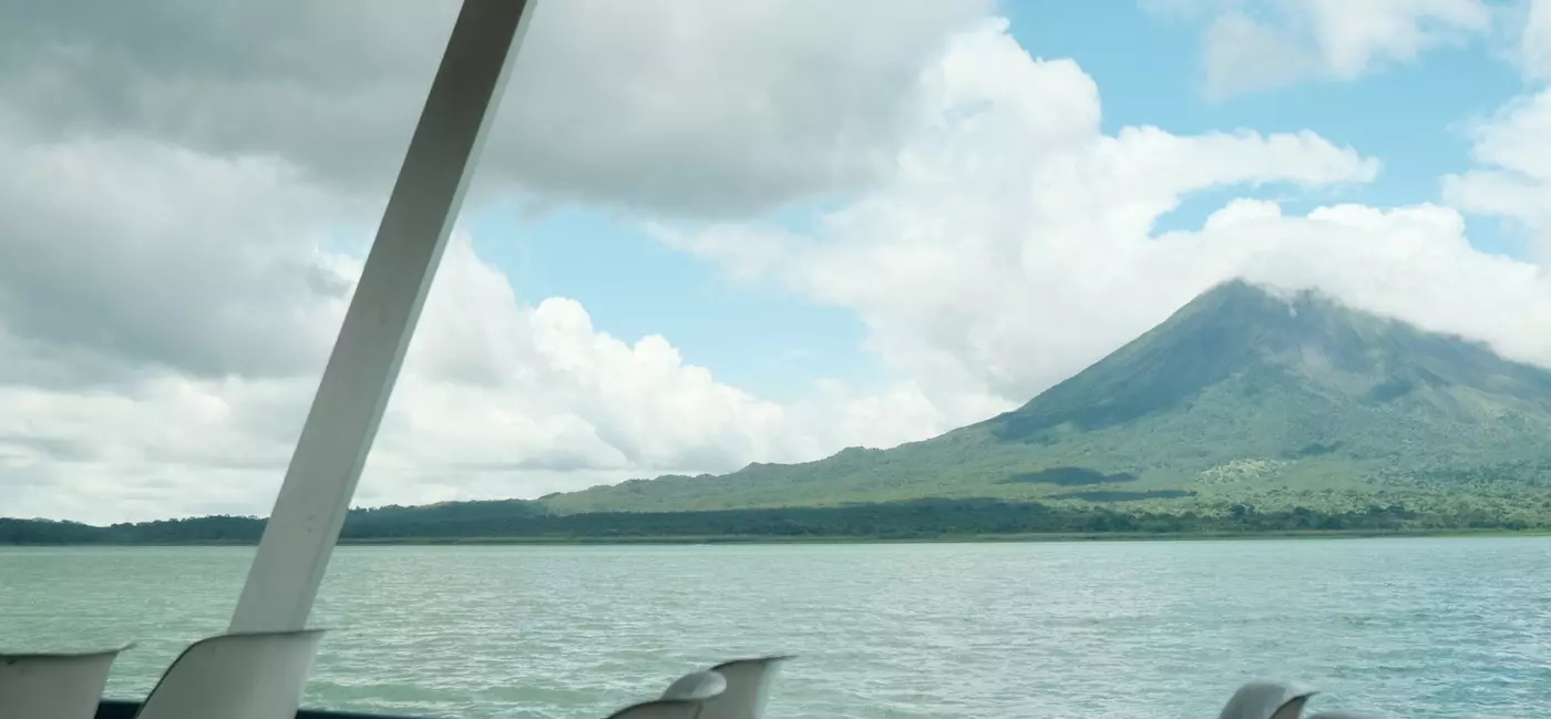 View from a ferry of a lake with a volcano in the background