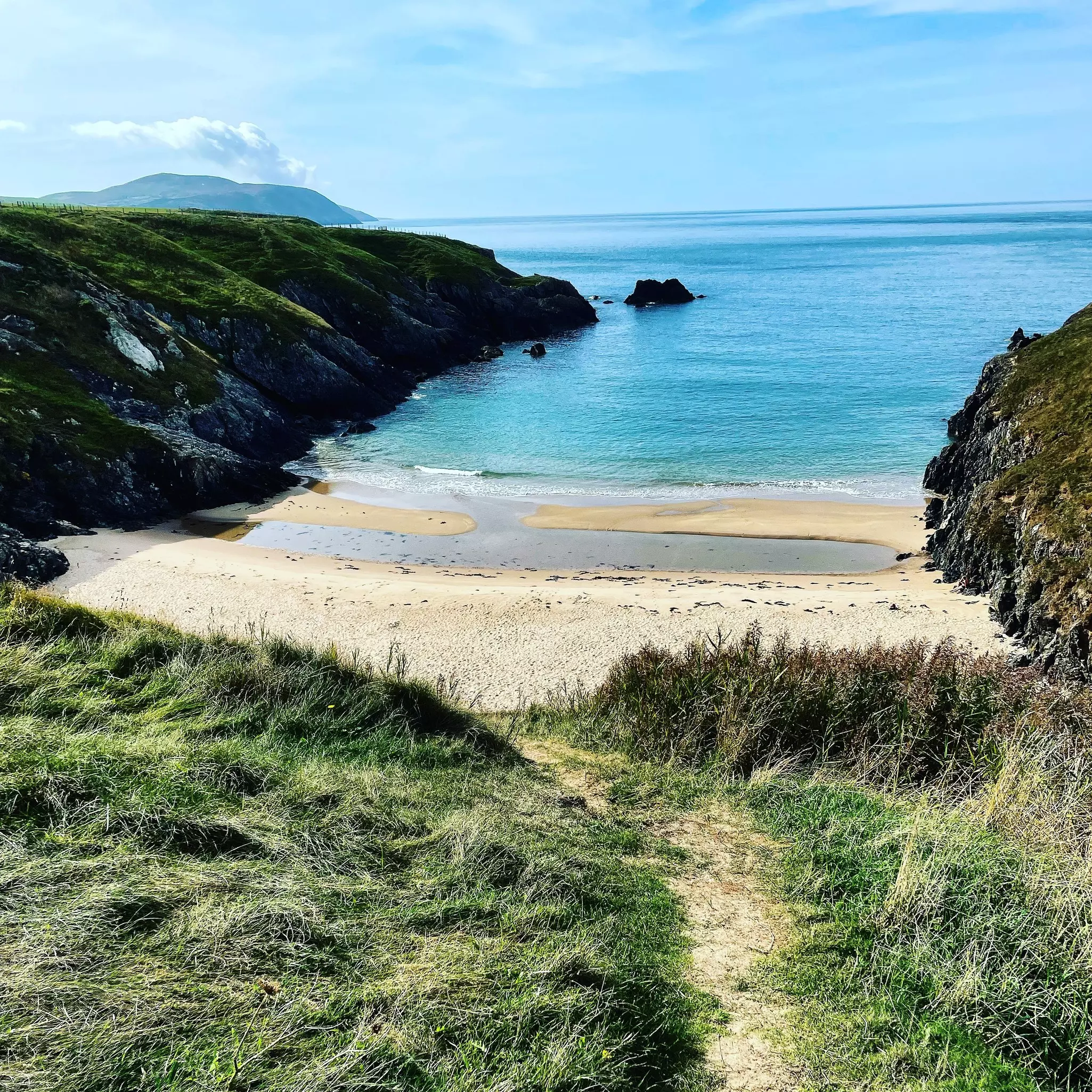 A sandy beach tucked within cliffs.