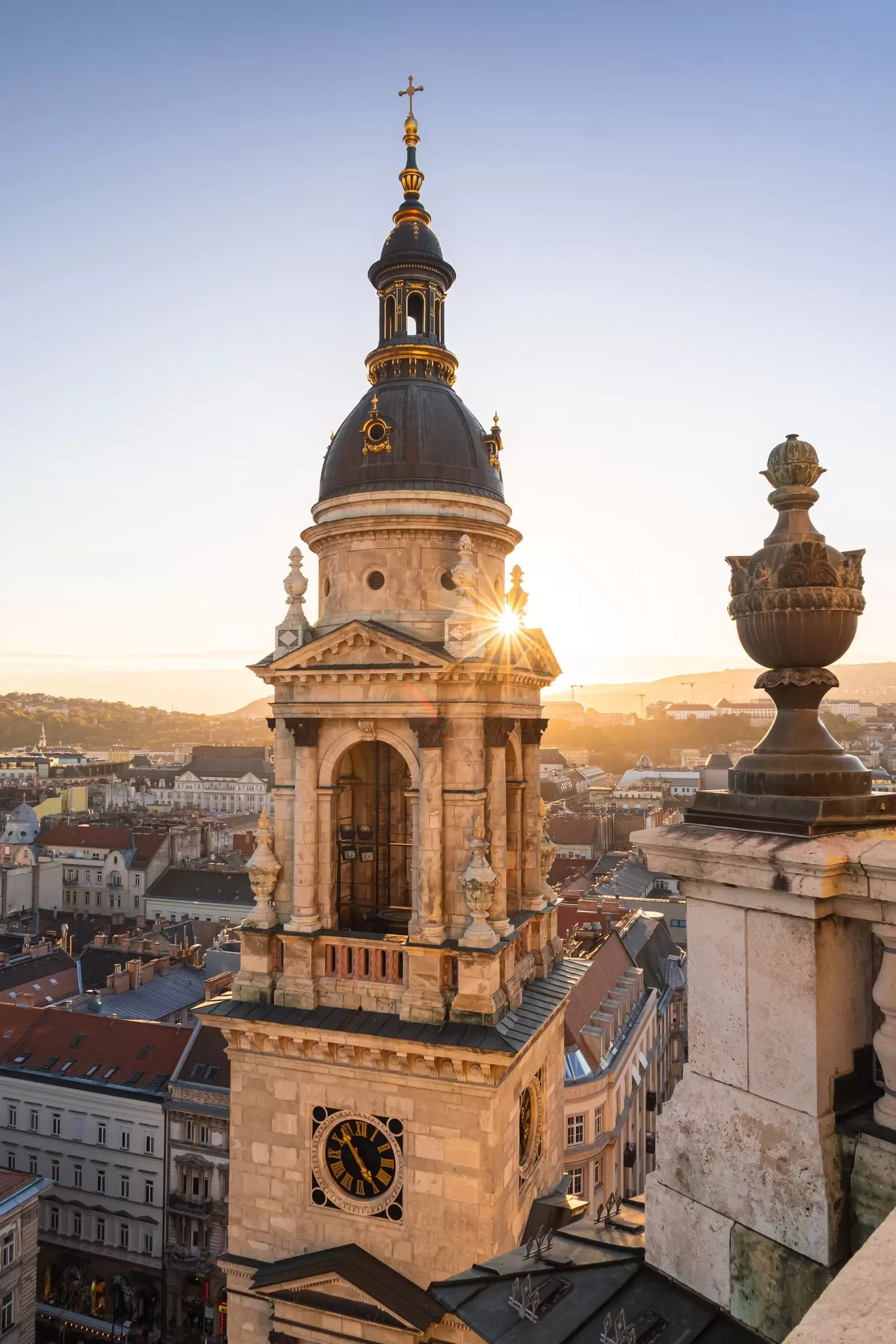 View of Budapest from the Basilica of St Stephen during sunset, with the church's bell tower in the foreground, in Budapest, Hungary.