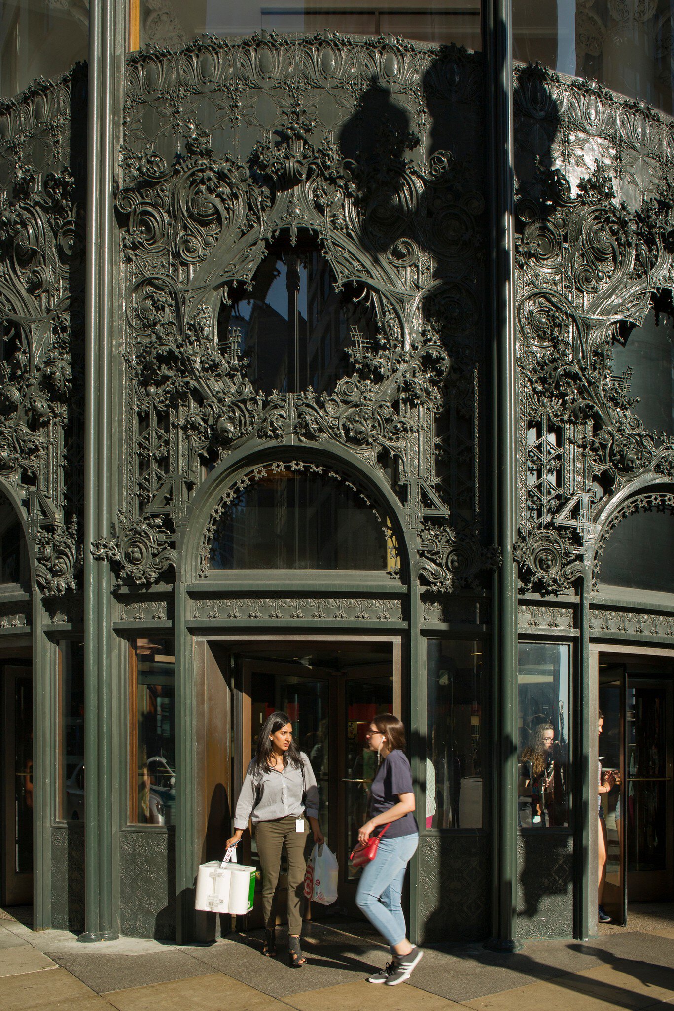 Shoppers walking by the Sullivan Center's northwest entrance with its cast-iron ornamental work in Chicago, Illinois.