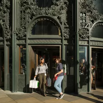 Shoppers walking by the Sullivan Center's northwest entrance with its cast-iron ornamental work in Chicago, Illinois.