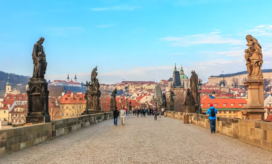 People walking across Charles Bridge in Prague, Czechia