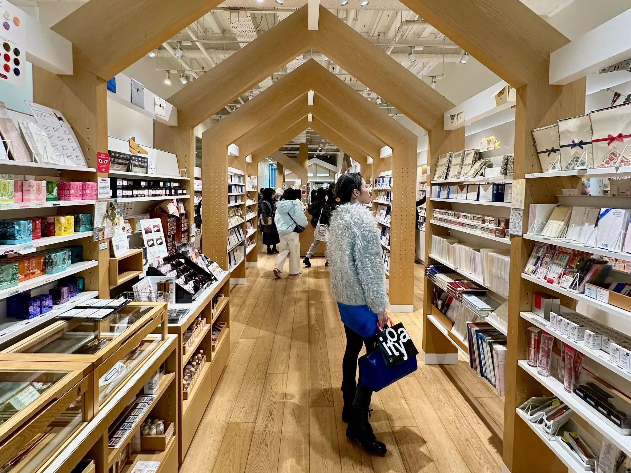 A shopper looking at a wall display of stationary in Tokyo.