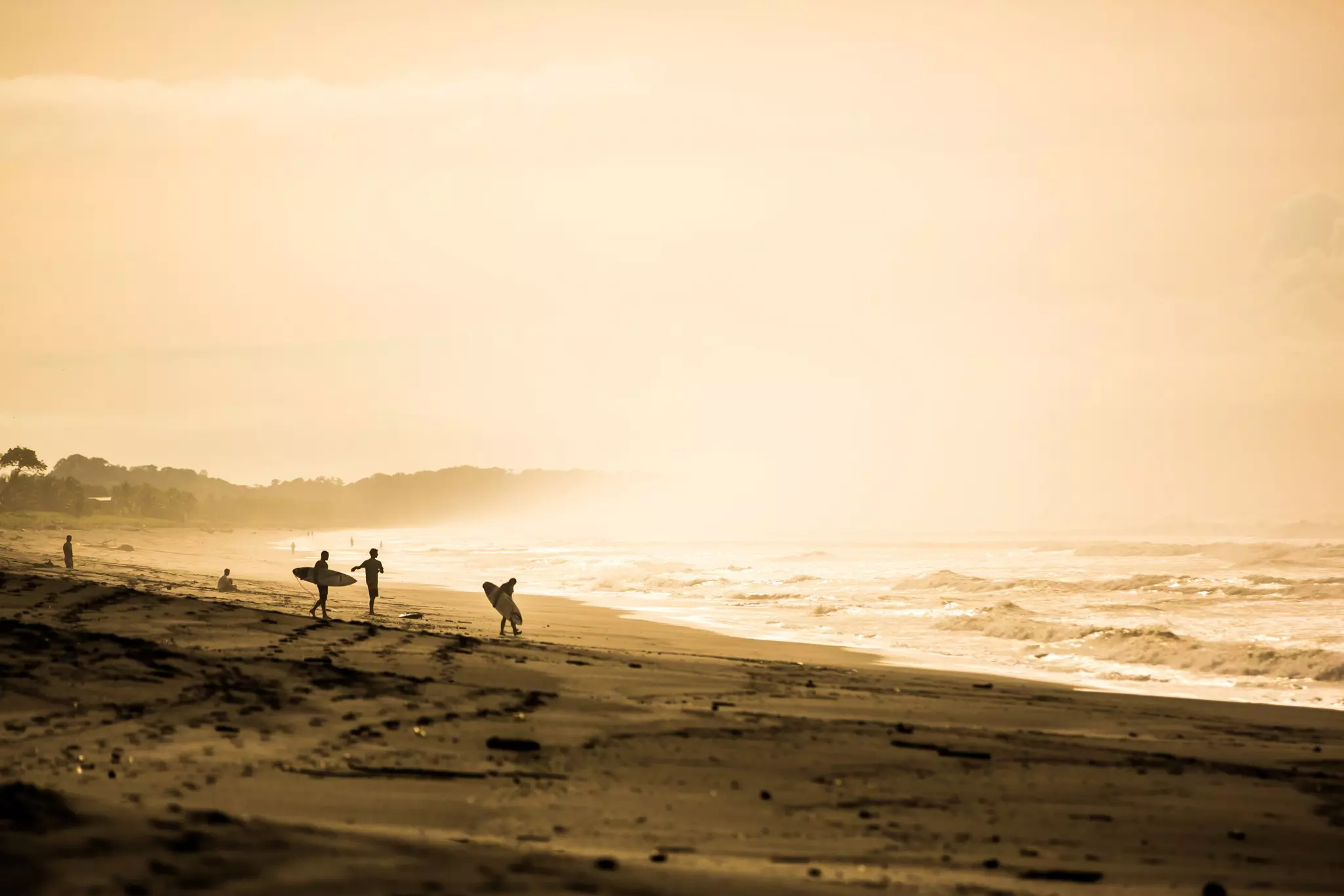 Surfers in the early morning at Playa Jacó.