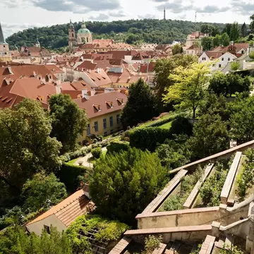 Prague, Czech Republic. View over the Palace Gardens below Prague Castle towards the dome of St Nicholas Church and Petřín with the lookout tower, Prague, on a bright summer afternoon.