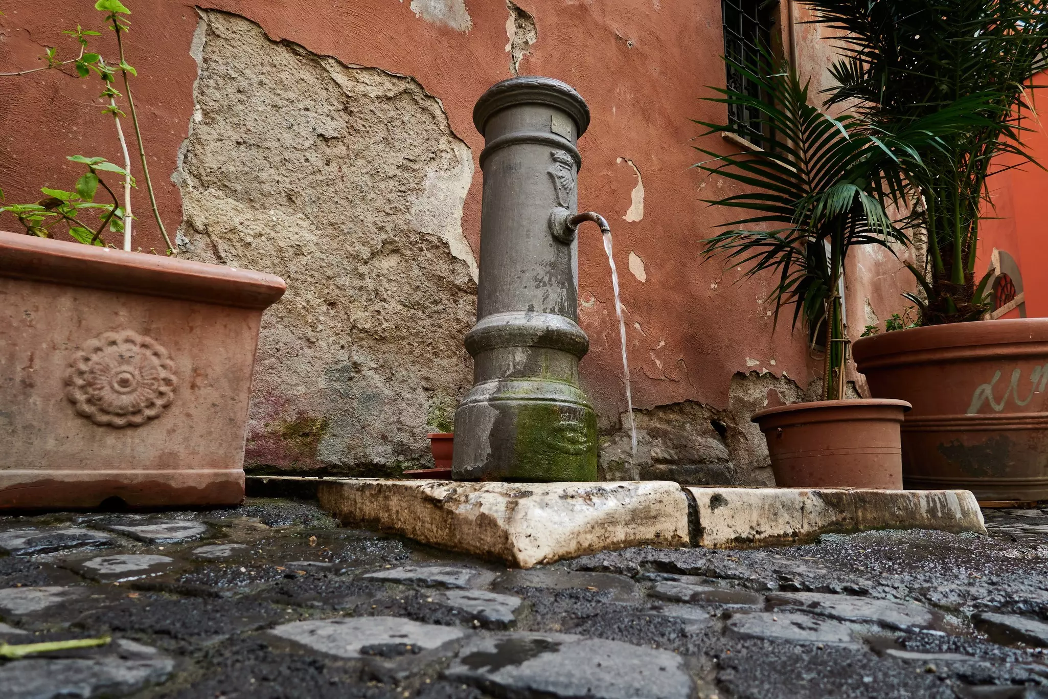 The nose-like spout of one of Rome's traditional nasoni water fountains, Italy.