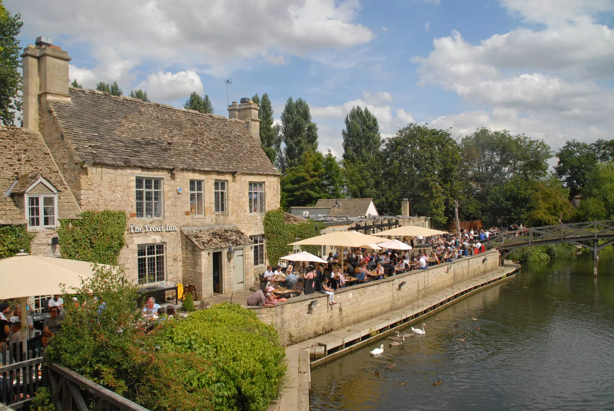 People drinking by the river side in the Trout Inn at Port Meadow, Oxford, England.