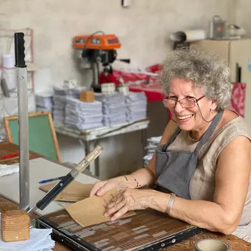Mary, the mother-in-law of Ciclo's founder, making event programs from recycled paper