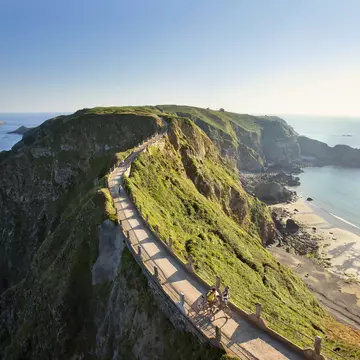 Cyclists on La Coupee; narrow isthmus that connects Big Sark to Little Sark.