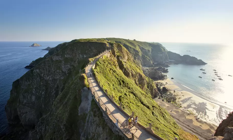 Cyclists on La Coupee; narrow isthmus that connects Big Sark to Little Sark.
