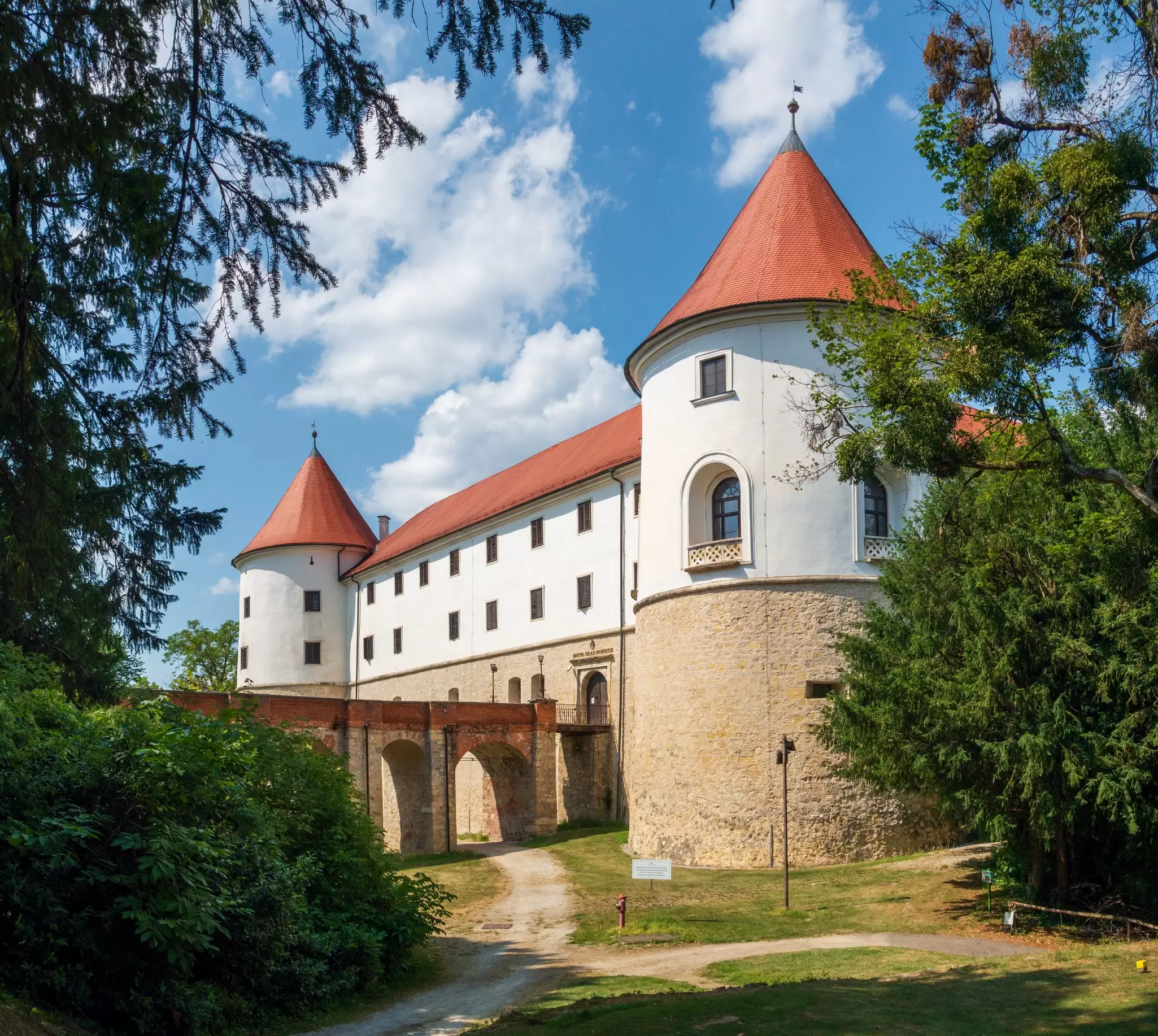 Large stone fortress with white walls and orange roof tiles.