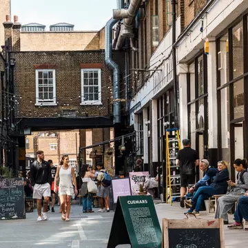 Street scene with people shopping in Dray Walk, a pedestrian street near Brick Lane in Shoreditch Area in the East End
