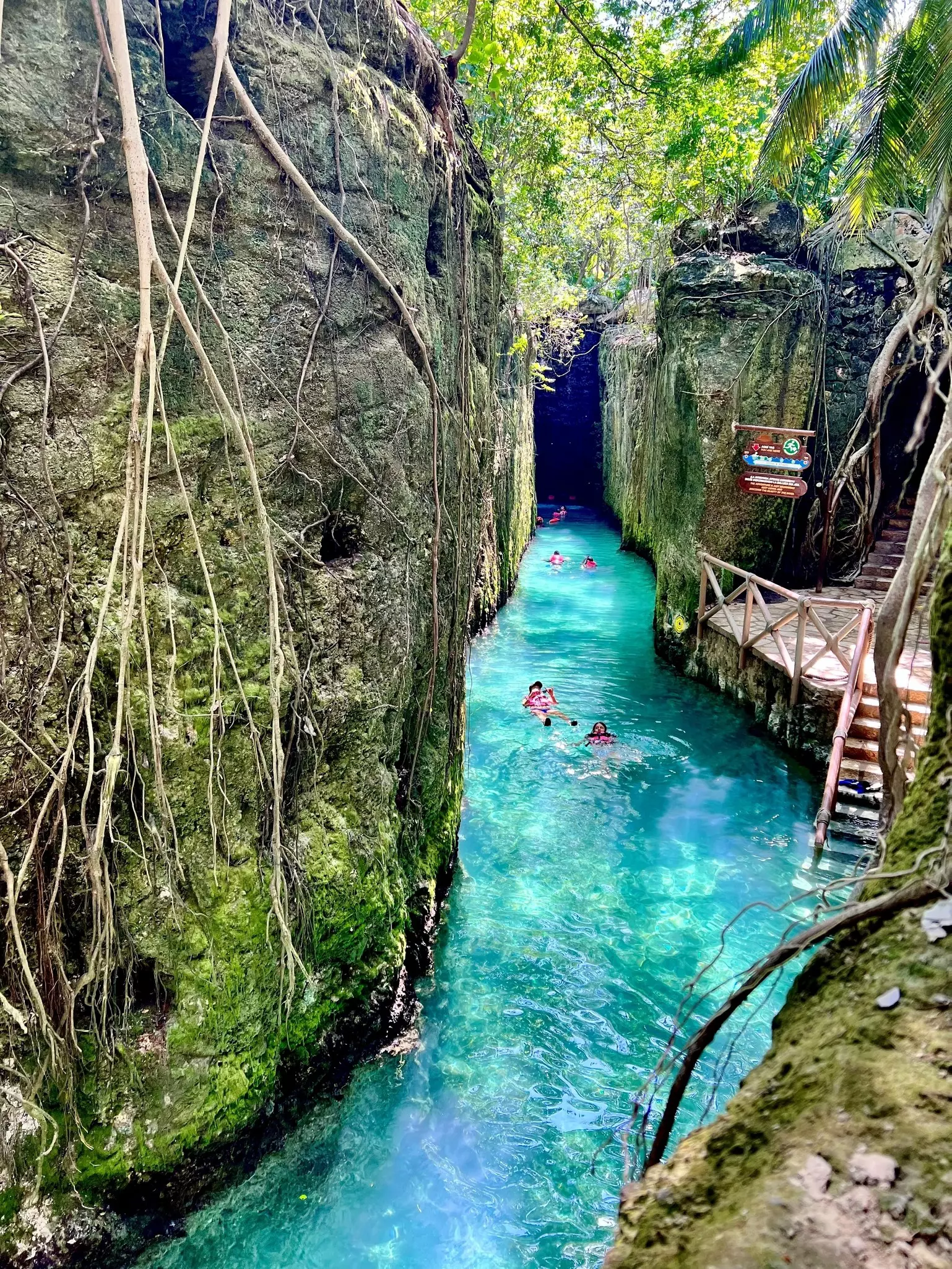 River tubing at the cave entrance at the ecological adventure paradise, Xcaret.  Floating along pristine, crystal clear, cool, jungle waters.