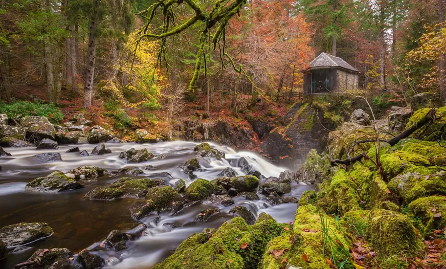 Ossian's Hall, a stone folly above the Black Linn falls on the River Braan, mossy boulders and autumn woods, Perthshire