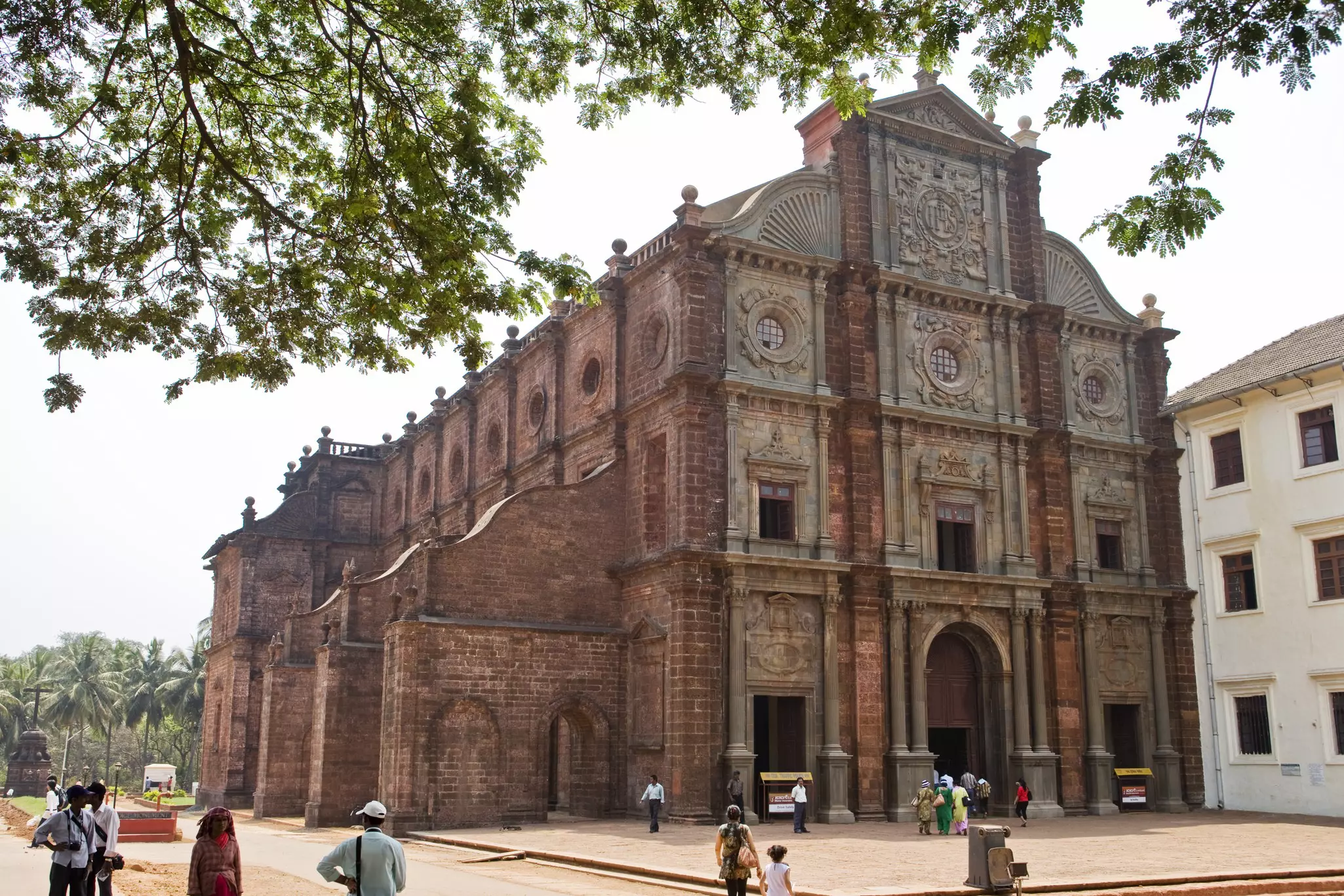 The exterior of a large brick church as people walk by.
