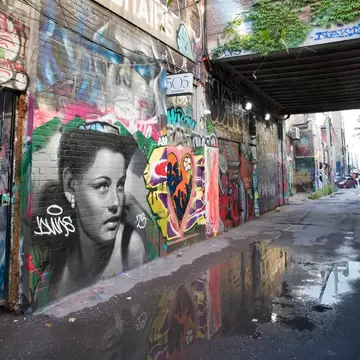 View of the Graffiti Alley featuring a mural of a woman in Toronto, Canada.