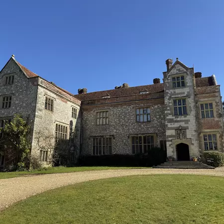 A three-story stone house with a pitched roof and an L-shaped wing.