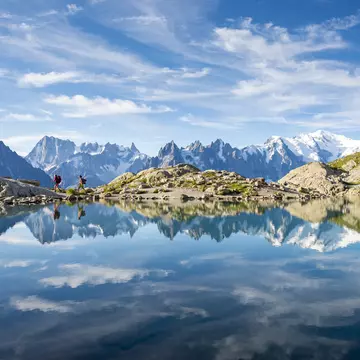 Hikers reflected in Lac Blanc on France's Tour du Mont Blanc trail. Alex Treadway/Getty Images