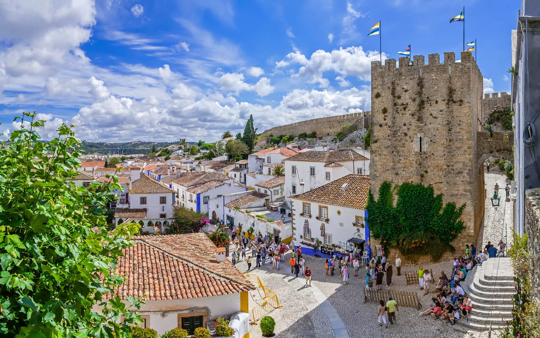 A medieval city with tourists wandering down the main pedestrianized street lined with shops and restaurants
