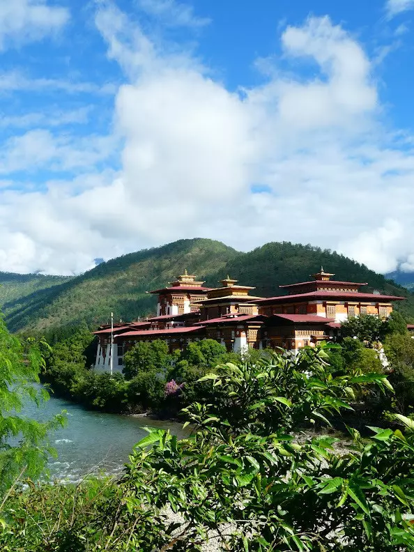 A large temple surrounded by trees and mountains.