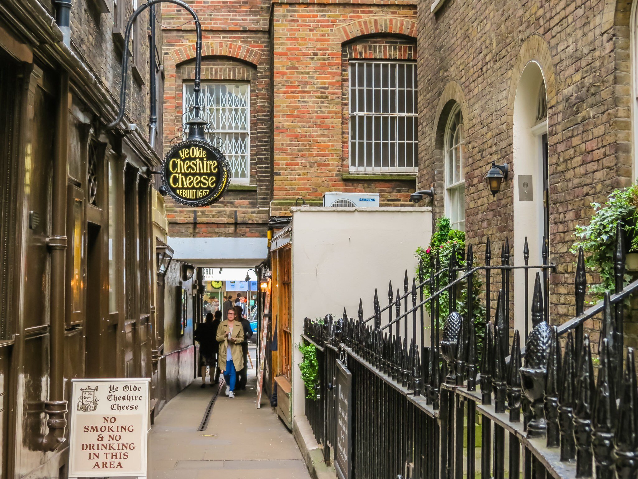 A pub sign hanging in an alleyway