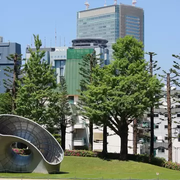 TOKYO, JAPAN - April 30, 2025: Garden of Tokyo Midtown in Roppongi with a modern sculpture and trees and skyscrapers in the background., License Type: media, Download Time: 2025-12-19T12:49:01.000Z, User: LP_YKhanna, Editorial: true, purchase_order: 65050 - Digital Destinations and Articles, job: LP, client: App Content, other: Yuvraj Khanna