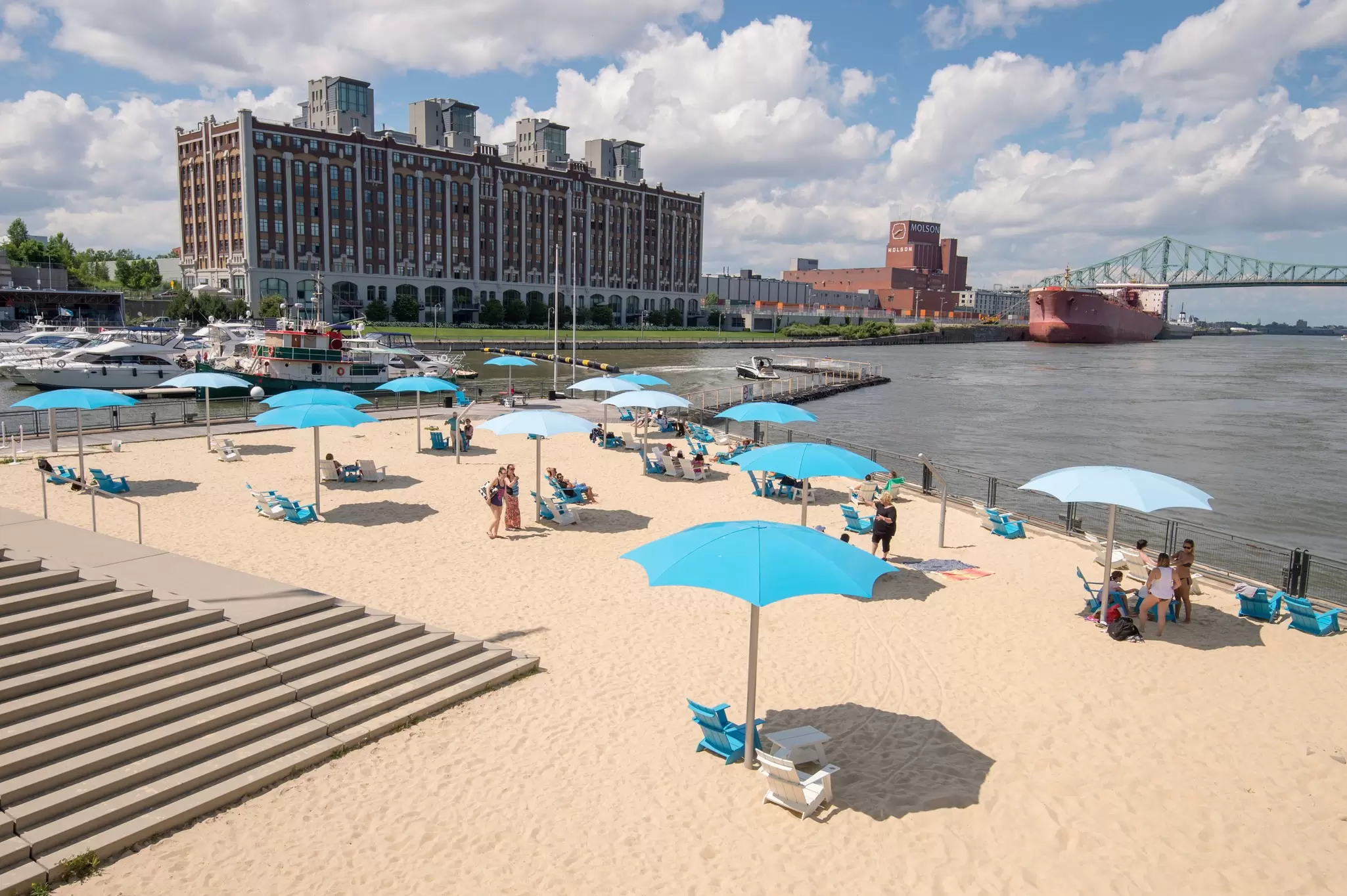 Sunbathers under umbrellas on a golden beach near Montreal, Canada