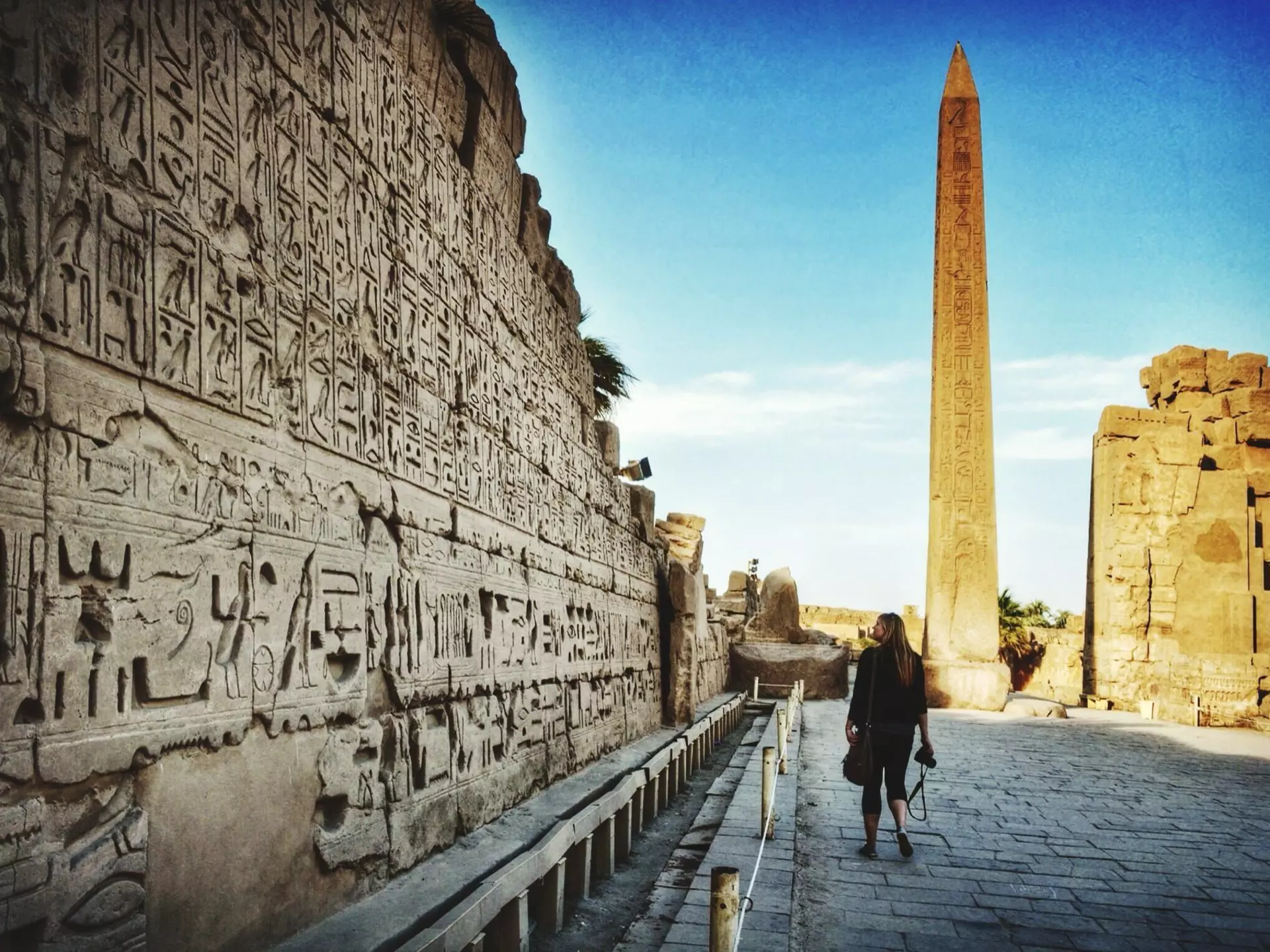 A woman walking past wall carvings at Karnak Temple.
580823575
Ancient, Architectural Feature, Architecture, Building Exterior, Built Structure, Casual Clothing, Day, Design, Famous Place, Flooring, Full Length, History, Karnak Temple, Leisure Activity, Lifestyles, Old, On The Move, One Person, Outdoors, Place Of Worship, Real People, Rear View, Religion, Spirituality, Sunlight, Temple - Building, Tourism, Tower, Travel, Travel Destinations, Walking, Women, 25-29 Years, Young Women