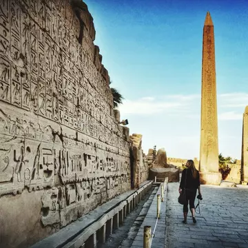 A woman walking past wall carvings at Karnak Temple.
580823575
Ancient, Architectural Feature, Architecture, Building Exterior, Built Structure, Casual Clothing, Day, Design, Famous Place, Flooring, Full Length, History, Karnak Temple, Leisure Activity, Lifestyles, Old, On The Move, One Person, Outdoors, Place Of Worship, Real People, Rear View, Religion, Spirituality, Sunlight, Temple - Building, Tourism, Tower, Travel, Travel Destinations, Walking, Women, 25-29 Years, Young Women