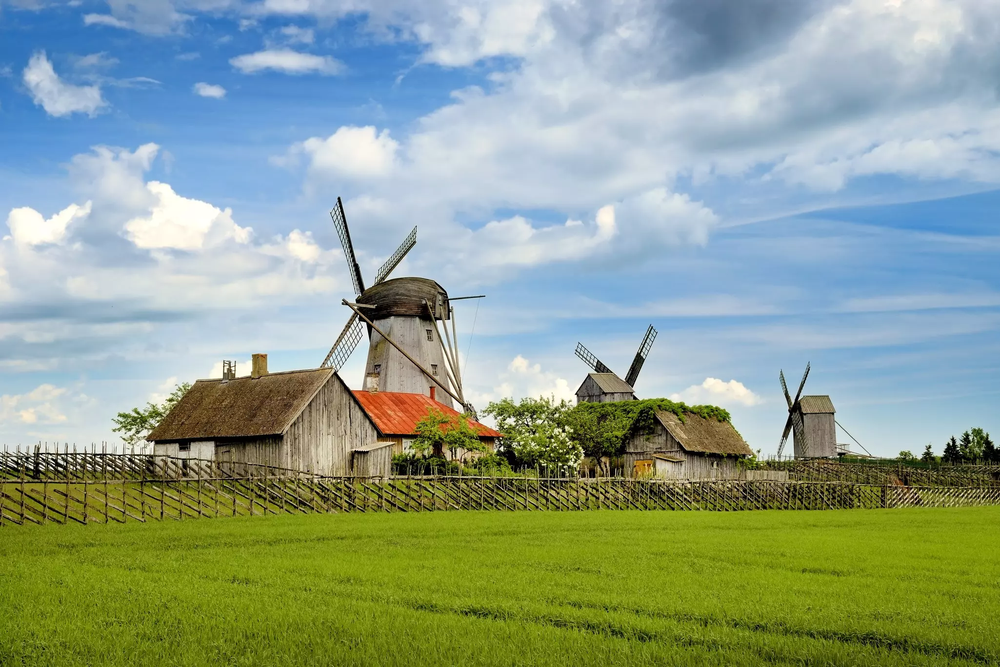 A small rural settlement with wooden houses and three wooden windmills.