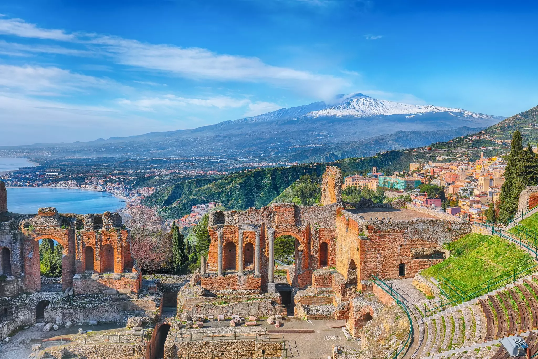 Mt Etna rises behind the Greek amphitheater in Taormina, Sicily. Vadym Lavra/Shutterstock