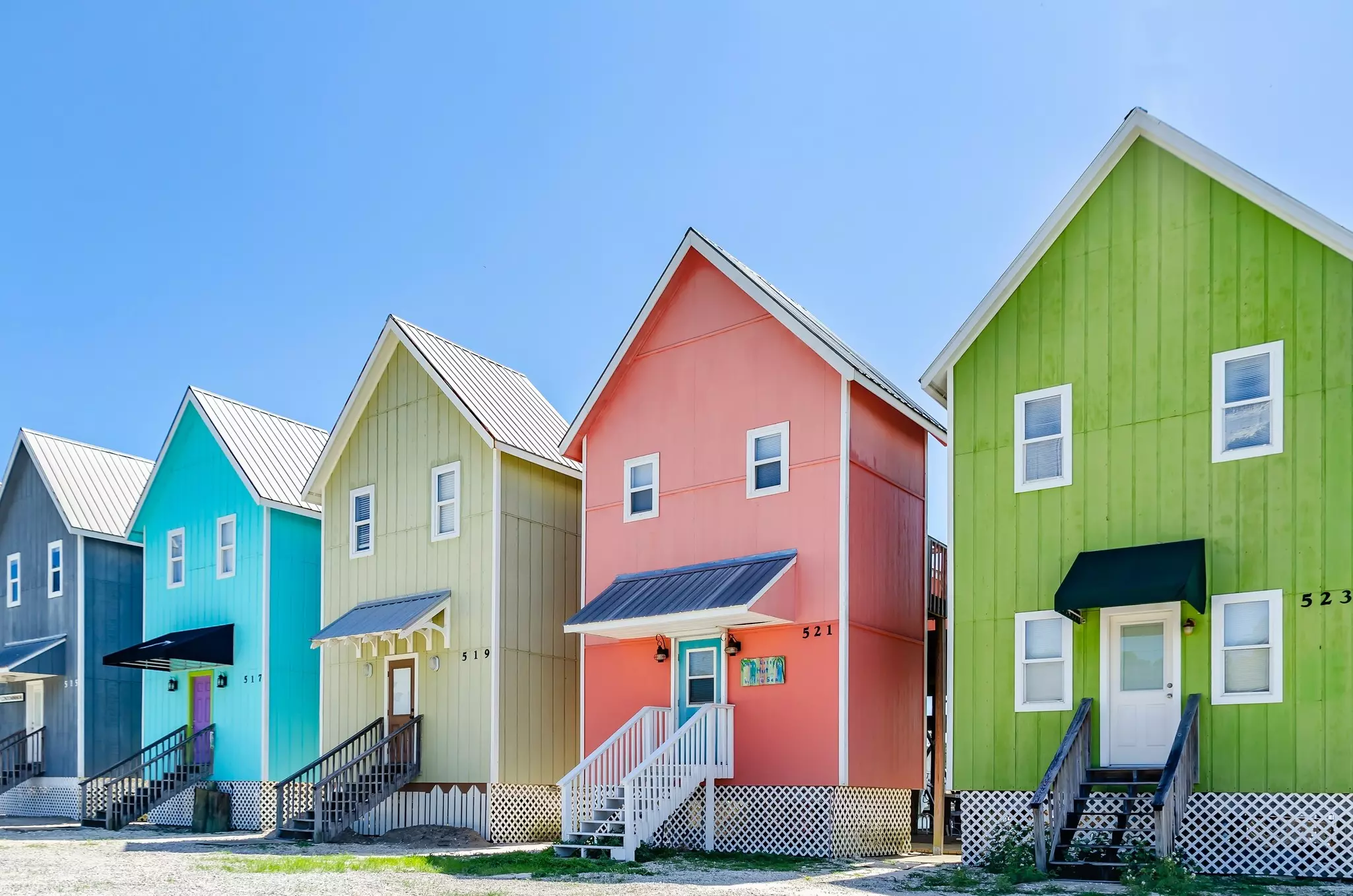 A row of colorful beach houses on bright, sunny day.