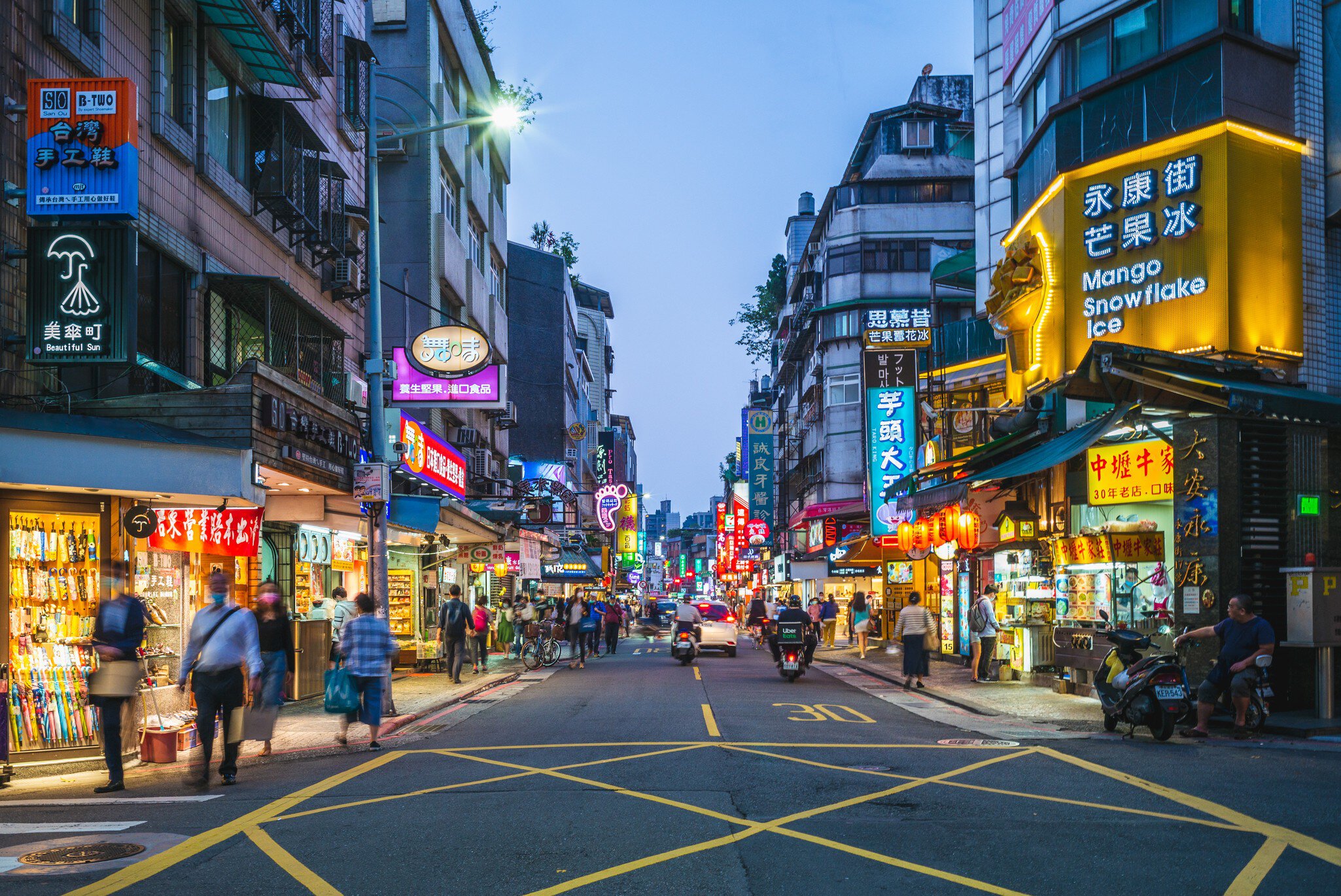 Yongkang Street in Taipei lit up at night with neon signs.