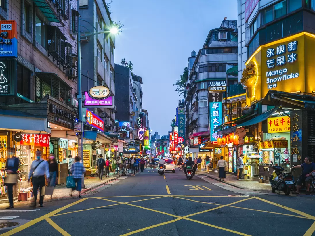 Yongkang Street in Taipei lit up at night with neon signs.