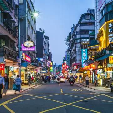 Yongkang Street in Taipei lit up at night with neon signs.