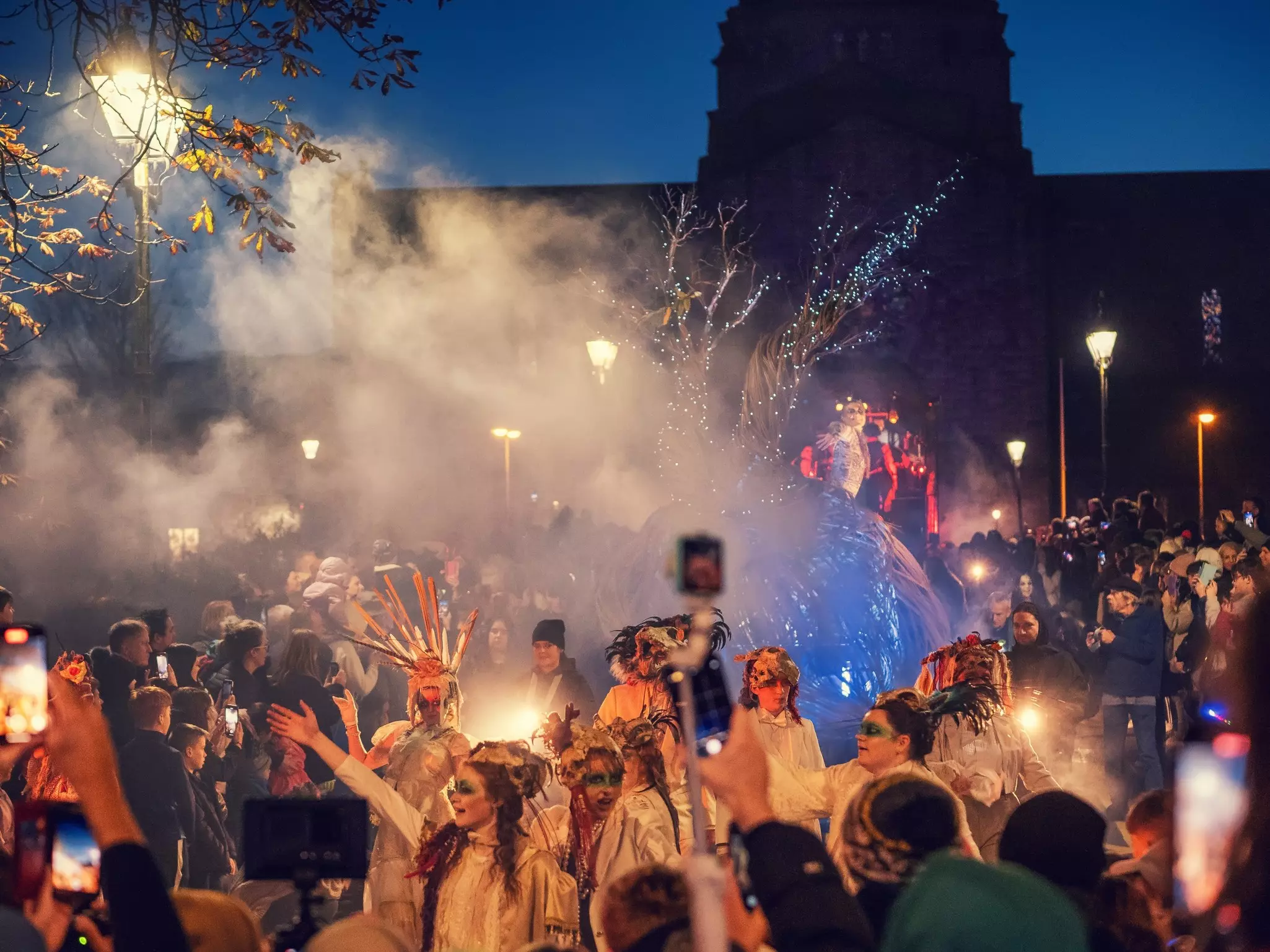 Macnas Halloween parade at Salmon Weir Bridge, with a cathedral in the background.