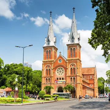 HCMC's Notre Dame Cathedral and the leafy surrounding square and street on a sunny, clear day
